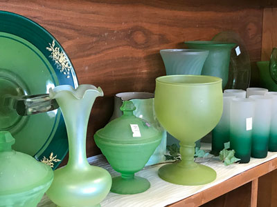 green glassware and vases at an estate sale